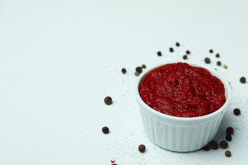 Bowl with tomato paste, pepper and salt on white background