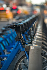 row of bicycles for hire on a busy city sidewalk