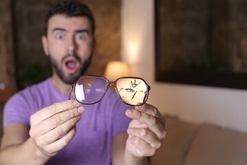Stressed out man breaking eyeglasses