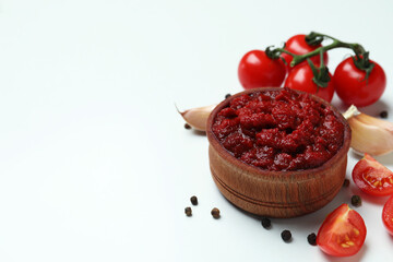 Bowl of tomato paste, tomatoes, pepper and garlic on white background