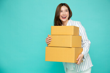 Happy Asian businesswoman smiling and holding package parcel box isolated on green background, Delivery courier and shipping service concept