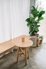 Interior of wooden table, label, seat, frame and fiddle fig tree in the cafe