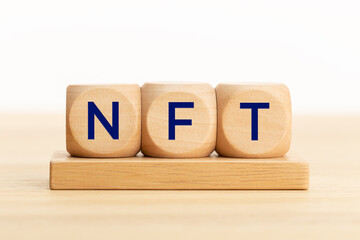 NFT text on wooden blocks. Non fungible token. Copy space. White background