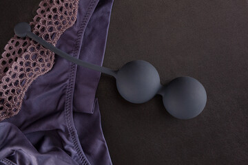 Kegel balls on panties on black background. Sex toy.