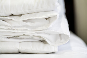 Fototapeta na wymiar Closeup of beautiful white shiny crumpled fabric sheets on the bed