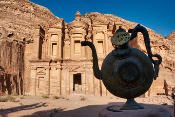 Old teapot in front of the carved temple of the Monastery in Petra