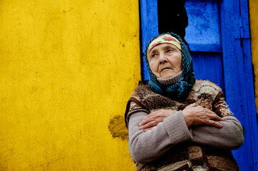 The old grandmother in the background of the slums. An elderly woman in a poor area. Grandmother on...