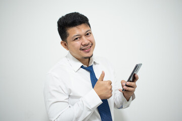 Young Asian businessman with mobile phone on light background