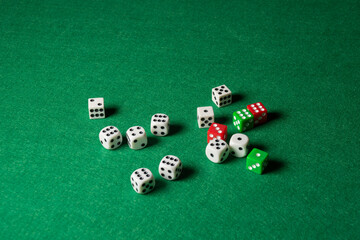 Wide shot of white, green and red dice on green playing mat, selective focus, horizontal, with copy space
