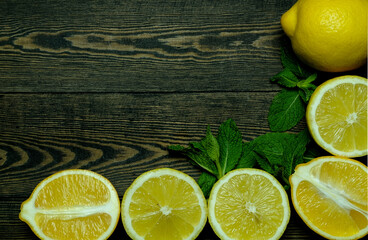 lemons with mint leaves on a dark wooden background   photographed from above in the form of a frame