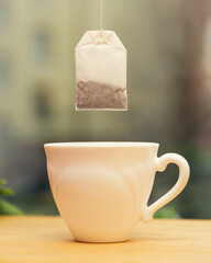 dry new disposable tea bag hanging over a white mug