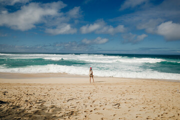 Girl watching the surf on the banzai pipeline on the north shore of the island of Oahu, Hawaii