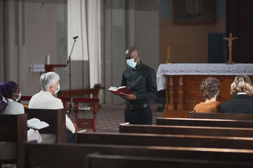 People sitting during Sunday mass in the church and listening to priest