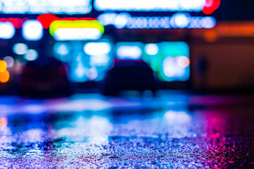 Rainy night. Parking mall with cars. Reflections of shop windows on wet asphalt. Colorful colors....