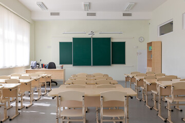 empty school class before final exams. desks and chairs are neatly arranged in three rows. overall plan