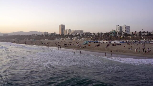 Beach with vacationers in Los Angeles at sunset. Los Angeles, USA - 14 Apr 2021