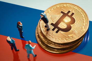 Business meeting about the investment decision for bitcoin concept: Miniature businessman figurines standing near the pile of shiny golden bitcoin on Russia flag.