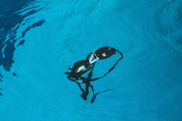 swimming goggles are on the parapet near the swimming pool. indoor swimming sports equipment