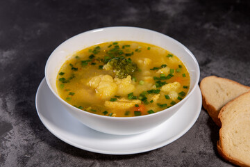 Vegetable soup. Serve the soup with bread. Ready-made vegetable lunch for lunch, hot soup for dinner at home. Soup with potatoes, carrots, broccoli, cauliflower and chicken fillet.