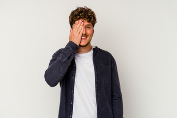 Young caucasian man isolated on white background having fun covering half of face with palm.