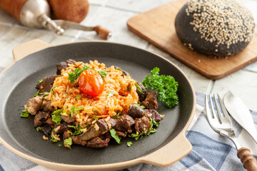 Indigenous Ghanaian, African-Caribian food Jollof Rice with tomato sauce, regional spices, chicken meat and offal..