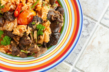 Indigenous Ghanaian, African-Caribian food Jollof Rice with tomato sauce, regional spices, chicken meat and offal..