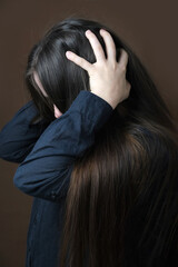 Fototapeta premium close-up girl, woman under pressure of various life problems in despair covered her face, which was distorted by protest, concept of suffering from stress, psychological violence, abuse