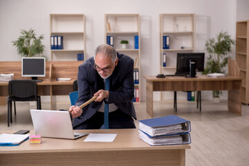Old businessman employee holding plunger at workplace