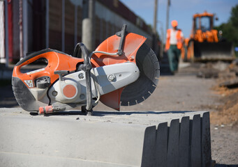 Close-up of concrete curbs with a circular saw on a construction site, road repairs.