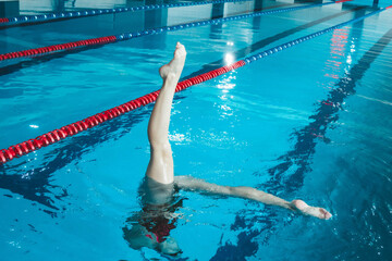 synchronized swimming athlete trains alone in the swimming pool. Training in the water upside down....