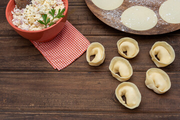 capeletinis and fresh raw homemade stuffed pasta with repulgue on wooden table and flour with tapas on plate and filling