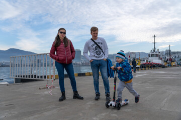 Batumi, Georgia - 08 February 2021: mom, dad and son are walking in the port