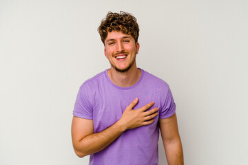Young caucasian man isolated on white background laughs out loudly keeping hand on chest.