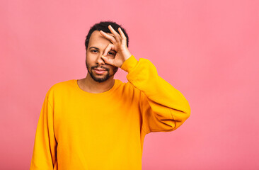 African american man isolated over pink background smiling positive doing ok sign with hand and fingers. Successful expression.