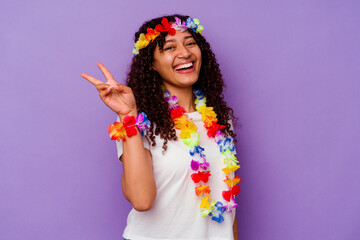 Young Hawaiian woman isolated on purple background joyful and carefree showing a peace symbol with fingers.