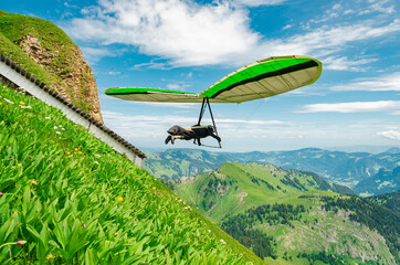 Hang glider pilots flies from steep slope