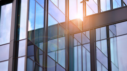 Modern office building detail, glass surface on a clear sky background. Transparent glass wall of office building.  