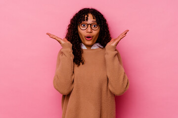 Young mixed race woman isolated on pink background surprised and shocked.