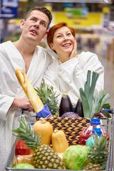 Caucasian couple family emotionally react on discounts in grocery store, in bathrobe