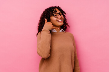 Young mixed race woman isolated on pink background showing a mobile phone call gesture with fingers.