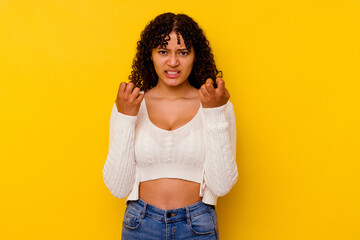 Young mixed race woman isolated on yellow background upset screaming with tense hands.