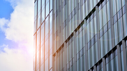 Fototapeta na wymiar Modern office building detail, glass surface on a clear sky background. Transparent glass wall of office building. 