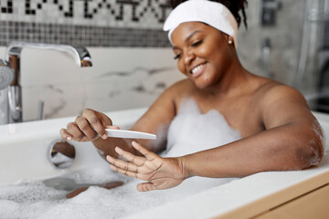 Portrait of nice good-looking african lady sawing nails while taking bath, close-up hands
