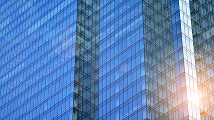 Fototapeta premium Modern office building detail, glass surface on a clear sky background. Transparent glass wall of office building. 