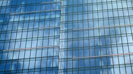 Modern office building detail, glass surface on a clear sky background. Transparent glass wall of office building.  