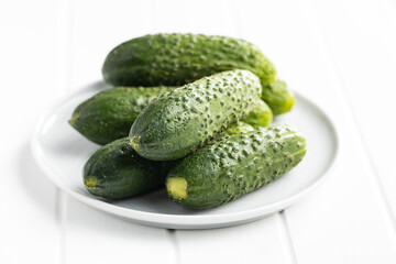 Fresh green cucumbers on white table.