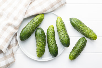 Fresh green cucumbers on white table.