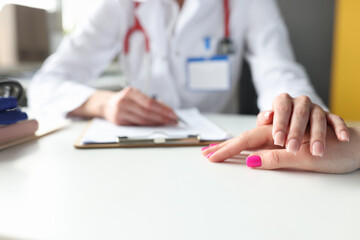 Doctor hand rests on patient hand, psychological support is provided