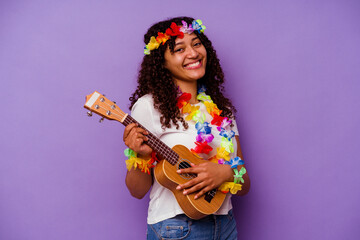 Young hawaiian woman playing ukelele isolated on purple background