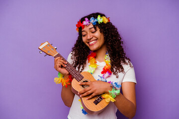Young hawaiian woman playing ukelele isolated on purple background